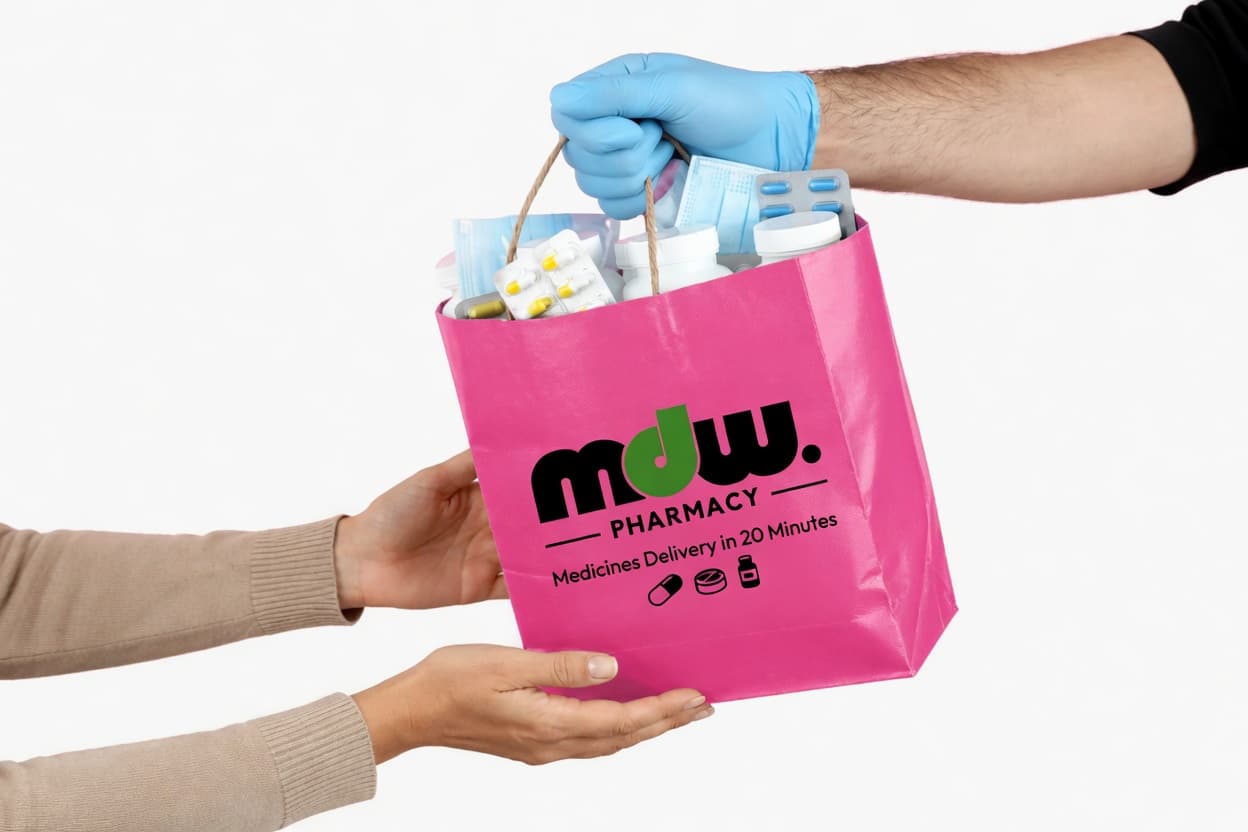 A gloved pharmacy hand handing over an mdw. Pharmacy bag of medicines.